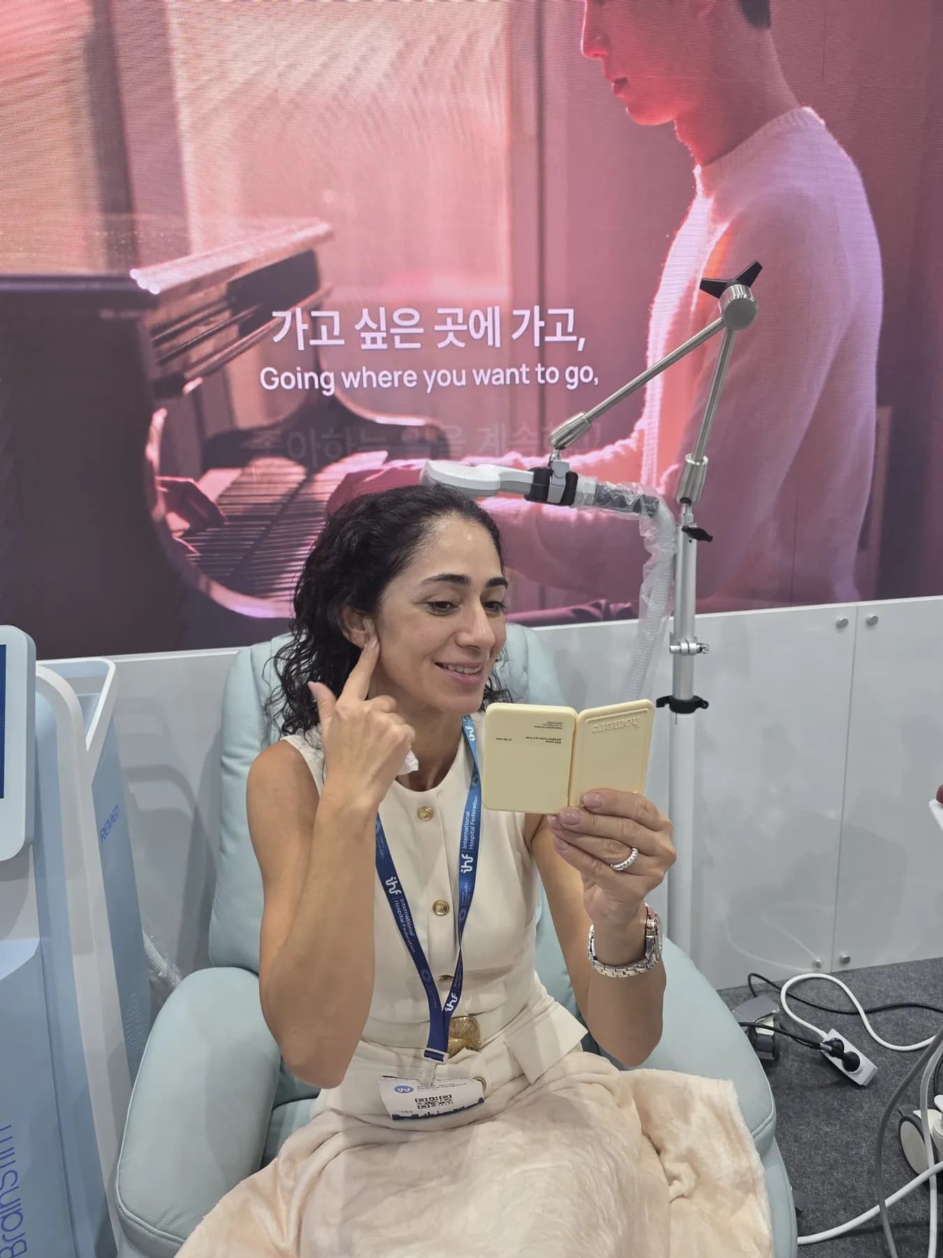 해외 참가자가 기기를 체험하며 거울을 보고 있습니다.